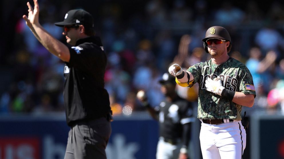 San Diego Padres' Jake Cronenworth, right, points toward the dugout after hitting a double against the Chicago White Sox as umpire Adam Beck calls time in the fourth inning a baseball game Sunday, Oct. 2, 2022, in San Diego. (AP Photo/Derrick Tuskan)