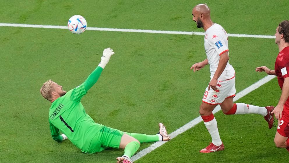 Tunisia's Issam Jebali, centre, misses a chance to score past Denmark's goalkeeper Kasper Schmeichel, left, during the World Cup group D soccer match between Denmark and Tunisia at the Education City Stadium in Al Rayyan, Qatar, Tuesday, Nov. 22, 202