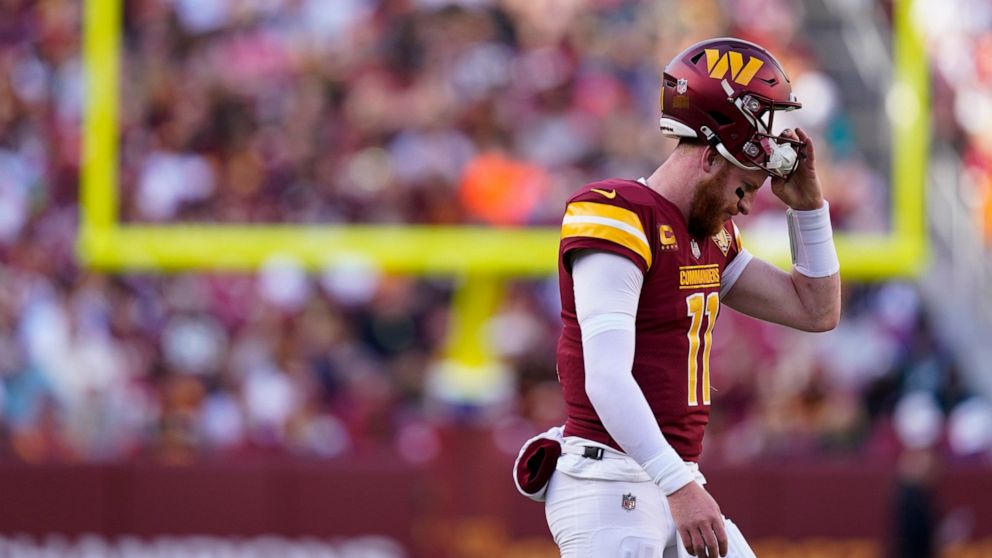 Washington Commanders quarterback Carson Wentz (11) walks to the sideline during a timeout during the first half of an NFL football game against the Cleveland Browns, Sunday, Jan. 1, 2023, in Landover, Md. (AP Photo/Patrick Semansky)