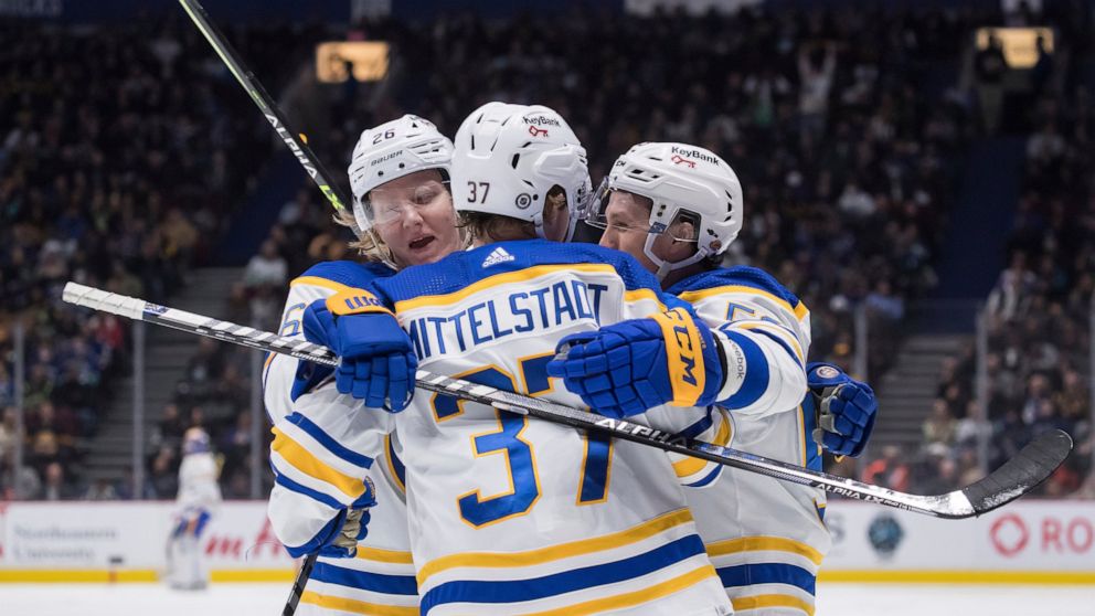 Buffalo Sabres' Jeff Skinner, right, celebrates his goal with teammates Rasmus Dahlin, of Sweden, left, and Casey Mittelstadt during the second period of an NHL hockey game against the Vancouver Canucks, in Vancouver, British Columbia, Sunday, March 