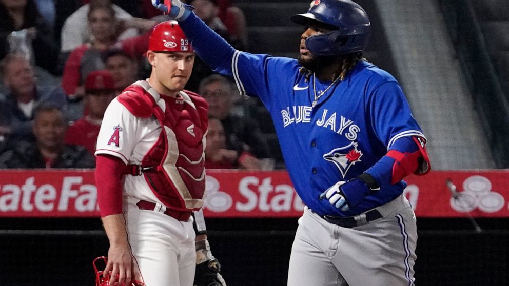 Toronto Blue Jays' Vladimir Guerrero Jr., right, gestures after hitting a solo home run as Los Angeles Angels catcher Max Stassi watches during the sixth inning of a baseball game Thursday, May 26, 2022, in Anaheim, Calif. (AP Photo/Mark J. Terrill)