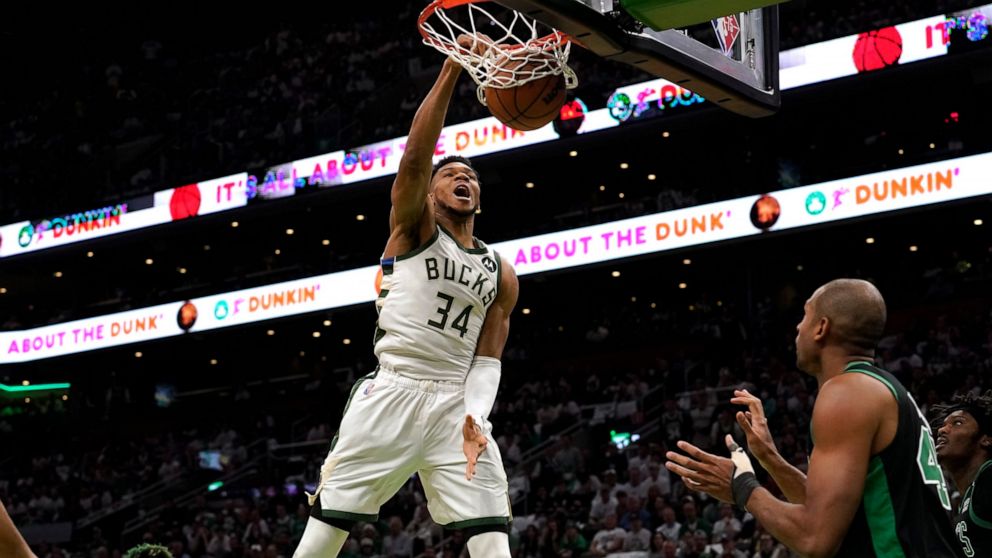 Milwaukee Bucks forward Giannis Antetokounmpo (34), of Greece, dunks as Boston Celtics guard Marcus Smart, left, and center Al Horford, right, look on in the first half of Game 1 in the second round of the NBA Eastern Conference playoff series, Sunda