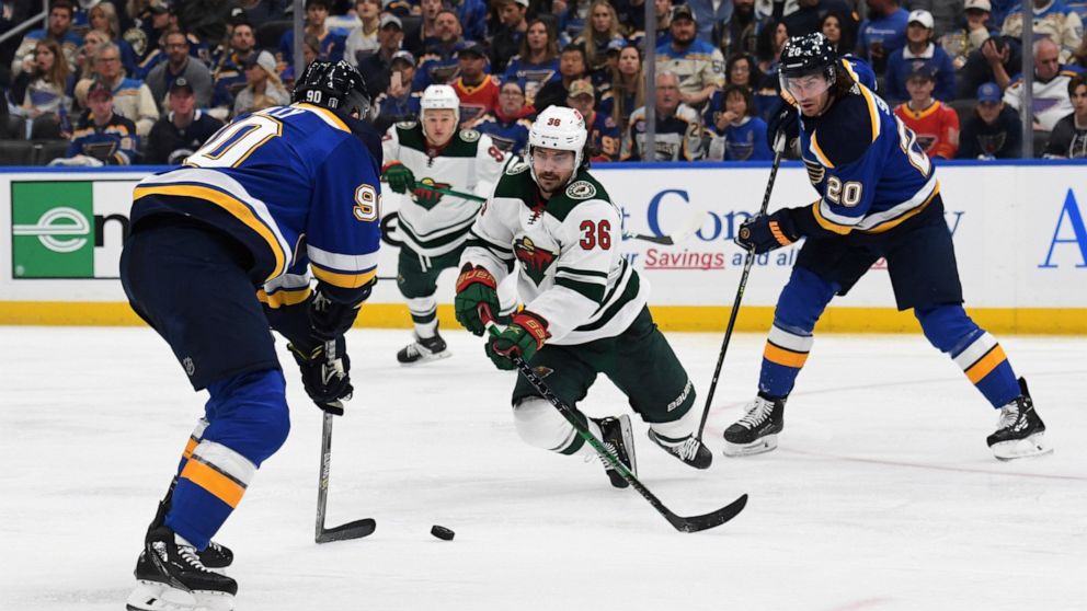 Minnesota Wild's Mats Zuccarello (36) lunges for the puck between St. Louis Blues' Ryan O'Reilly (90) and Brandon Saad (20) during the second period in Game 3 of an NHL hockey Stanley Cup first-round playoff series Friday, May 6, 2022, in St. Louis. 