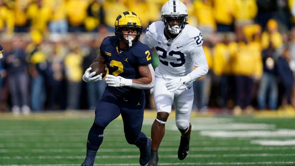 Michigan running back Blake Corum (2) runs the ball as Penn State linebacker Curtis Jacobs (23) chases in the first half of an NCAA college football game in Ann Arbor, Mich., Saturday, Oct. 15, 2022. (AP Photo/Paul Sancya)