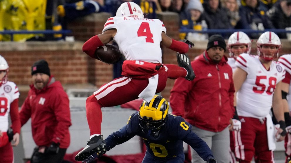 Nebraska wide receiver Alante Brown (4) tries to hurdle Michigan defensive back Mike Sainristil (0) in the first half of an NCAA college football game in Ann Arbor, Mich., Saturday, Nov. 12, 2022. (AP Photo/Paul Sancya)