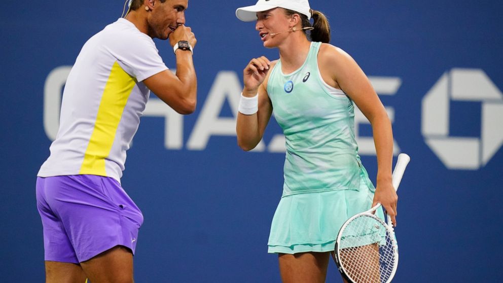 Rafael Nadal, of Spain, left, speaks to Iga Swiatek, of Poland, during "The Tennis Plays for Peace" exhibition match to raise awareness and humanitarian aid for Ukraine Wednesday, Aug. 24, 2022, in New York. The 2022 U.S. Open Main Draw will begin on