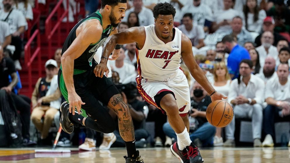 Miami Heat guard Kyle Lowry (7) dribbles the ball around Boston Celtics forward Jayson Tatum (0) during the first half of Game 5 of the NBA basketball Eastern Conference finals playoff series, Wednesday, May 25, 2022, in Miami. (AP Photo/Lynne Sladky)