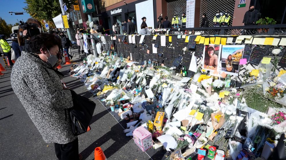 A woman wipes her tears as she pays tribute to victims of a deadly accident that happened during Saturday night's Halloween festivities, at a makeshift flower-laying area set up near the scene of the accident in Seoul, South Korea, Wednesday, Nov. 2,