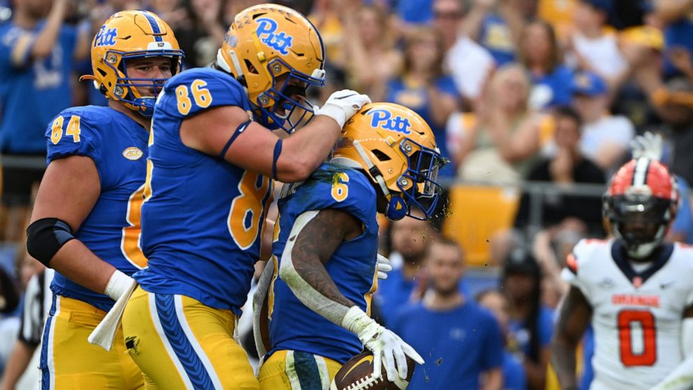 Pittsburgh running back Rodney Hammond Jr. (6) celebrates with tight end Gavin Bartholomew (86) after scoring a touchdown during the first half of an NCAA college football game against Syracuse, Saturday, Nov. 5, 2022, in Pittsburgh. (AP Photo/Barry 