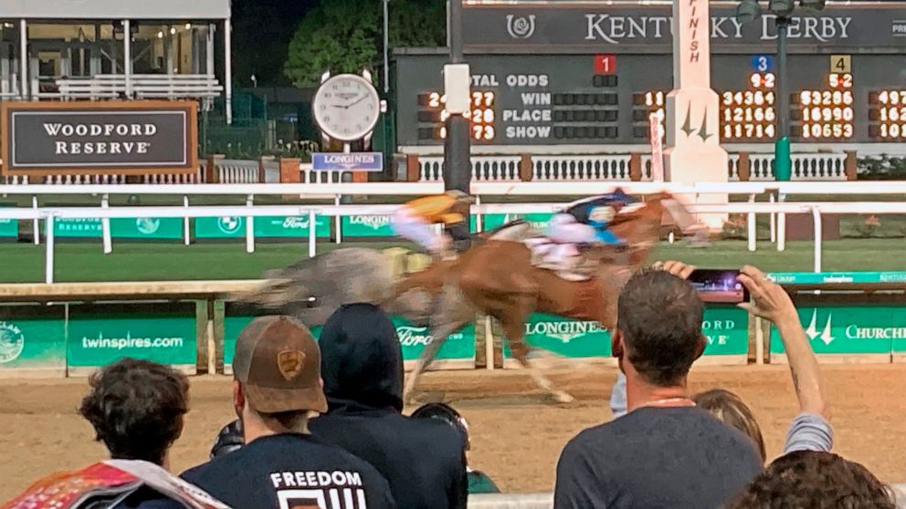 Spectators look on as horses approach the finish of a race at Churchill Downs in Louisville, Ky., Saturday, April 30, 2022. After the COVID-postponed 2020 race was run on Labor Day without spectators and went off last May with limited capacity, the K