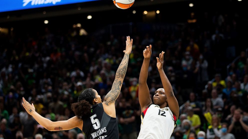 Las Vegas Aces guard Chelsea Gray (12) shoots over Seattle Storm forward Gabby Williams (5) during the first half in Game 3 of a WNBA basketball semifinal playoff series Sunday, Sept. 4, 2022, in Seattle. (AP Photo/Lindsey Wasson)