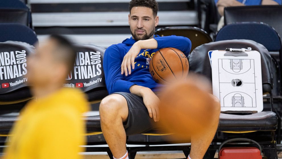 Golden State Warriors' Klay Thompson sits on the bench watching teammates during practice for the NBA Finals against the Toronto Raptors Tuesday, June 4, 2019, in Oakland, Calif. Game 3 of the NBA Finals is Wednesday, June 5, 2019, in Oakland, Calif.