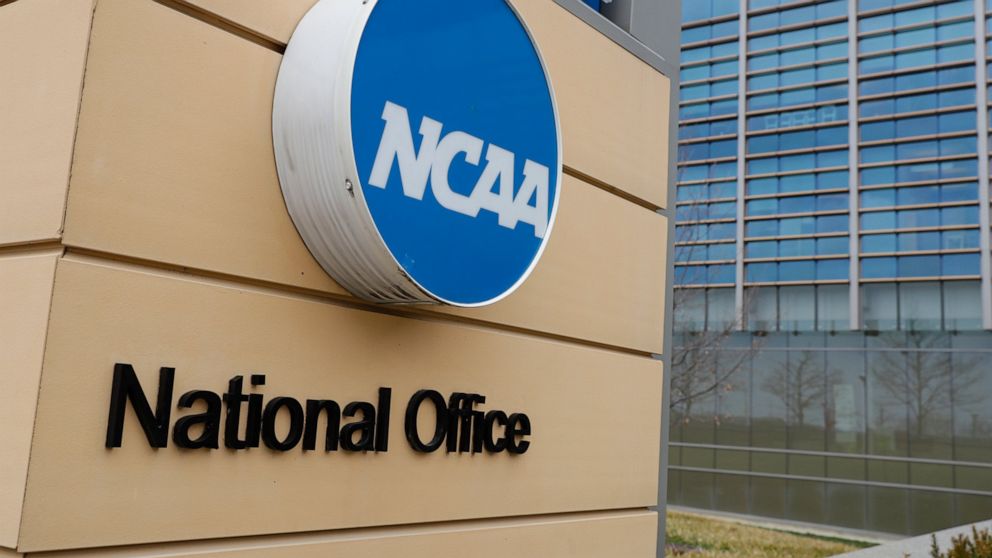 FILE - Signage at the headquarters of the NCAA is viewed in Indianapolis, March 12, 2020. By trying to limit how much schools can help college athletes cashing in on their fame, the NCAA seems to have inadvertently opened the door for boosters to get