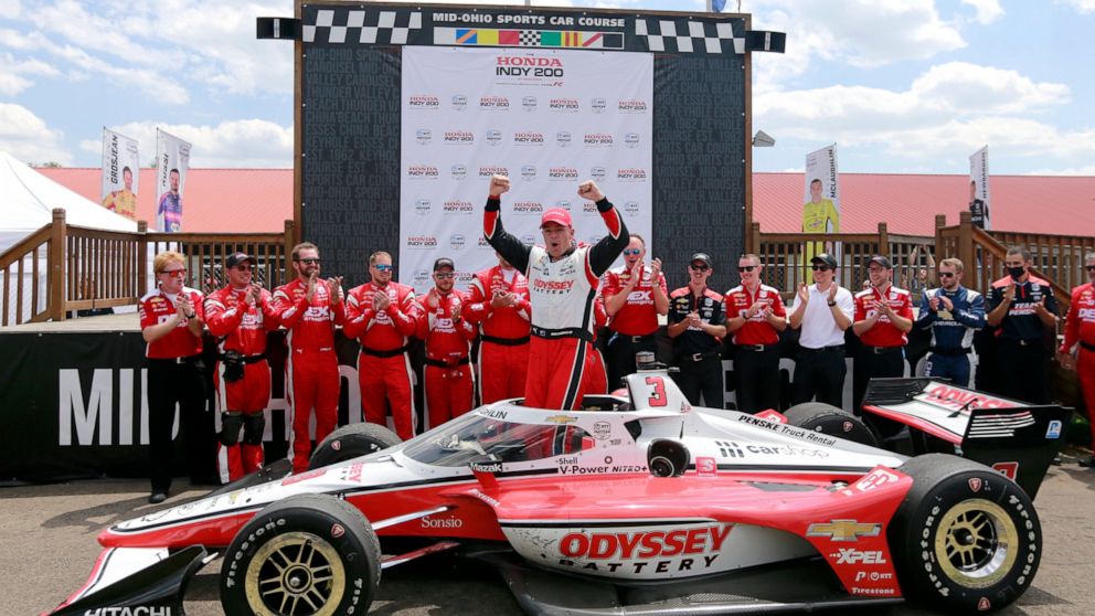 Scott McLaughlin, center, celebrates in Victory Circle after winning an IndyCar auto race at Mid-Ohio Sports Car Course in Lexington, Ohio, Sunday, July 3, 2022. (AP Photo/Tom E. Puskar)