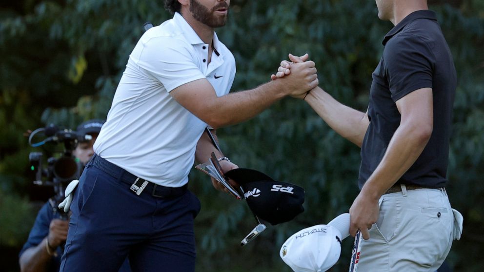 Matthew Wolff, left, shakes hands with Martin Kaymer after they finished the first round of the LIV Golf Invitational-Boston tournament, Friday, Sept. 2, 2022, in Bolton, Mass. (AP Photo/Mary Schwalm)