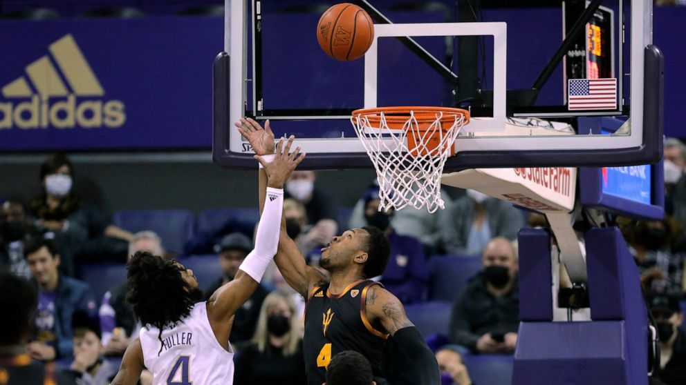 Arizona State's Kimani Lawrence tips the ball in for a basket as Washington's PJ Fuller defends during the first half of an NCAA college basketball game Thursday, Feb. 10, 2022, in Seattle. (AP Photo/John Froschauer)