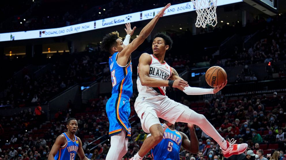 Portland Trail Blazers guard Anfernee Simons, right, looks to pass the ball as Oklahoma City Thunder guard Tre Mann defends during the first half of an NBA basketball game in Portland, Ore., Friday, Feb. 4, 2022. (AP Photo/Craig Mitchelldyer)