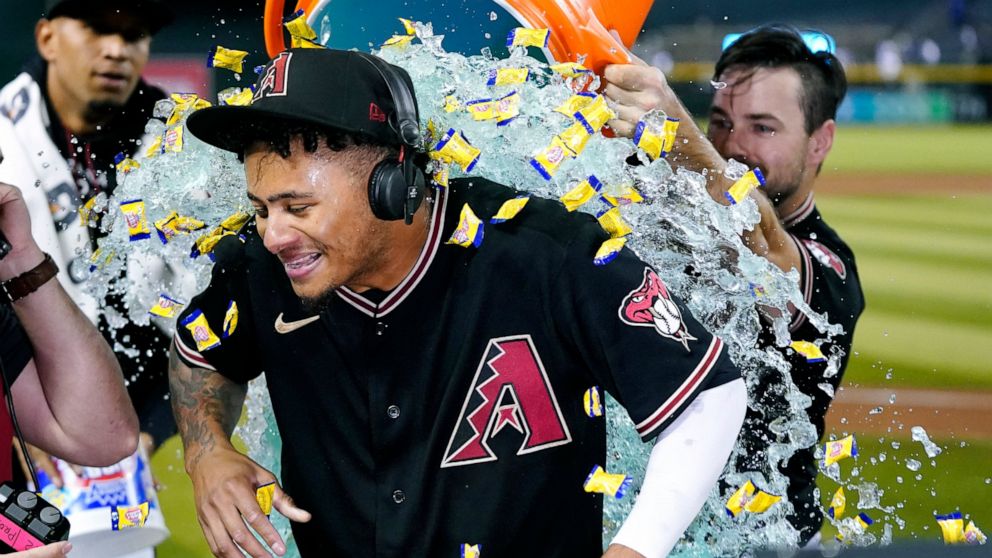 Arizona Diamondbacks' Sergio Alcantara gets showered with liquid and bubble gum by Cooper Hummel, right, after his game-ending, three-run home run in the 10th inning against the Los Angeles Dodgers in a baseball game in Phoenix, Wednesday, Sept. 14, 