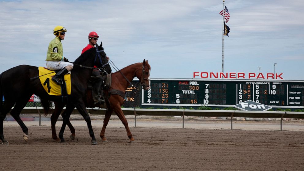 A jockey and handler ride their horses down the track between races at Fonner Park in Grand Island, Nebraska, on Friday, May 20, 2022. Horse tracks have been struggling for decades, but after Nebraska legalized casino gambling at the state's six lice