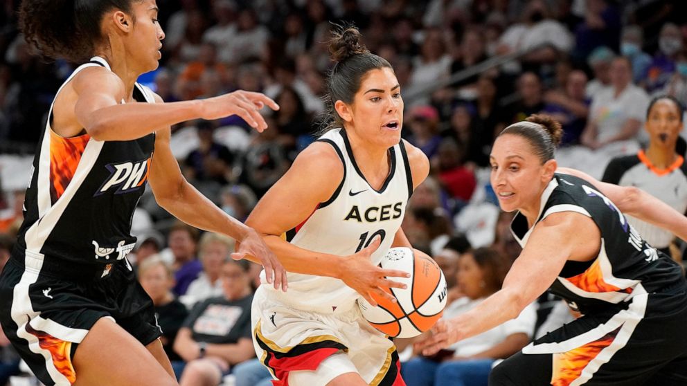 Las Vegas Aces' Kelsey Plum (10) drives to the basket between Phoenix Mercury's Skyler Diggins-Smith, left, and Diana Taurasi, right, during the first half of a WNBA basketball game Friday, May 6, 2022, in Phoenix. (AP Photo/Darryl Webb)