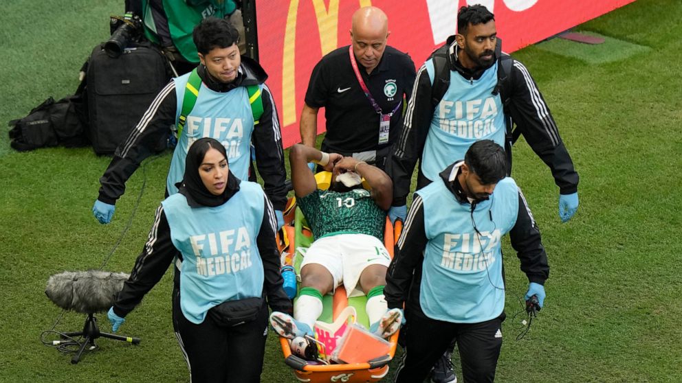 Paramedics carry Saudi Arabia's Yasser Al-Shahrani on a stretcher during the World Cup group C soccer match between Argentina and Saudi Arabia at the Lusail Stadium in Lusail, Qatar, Tuesday, Nov. 22, 2022. (AP Photo/Luca Bruno)