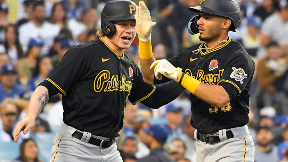 Pittsburgh Pirates' Jack Suwinski, left, congratulates Tucupita Marcano on his three-run home run while facing Los Angeles Dodgers starting pitcher Walker Buehler (21) during the second inning of a baseball game Monday, May 30, 2022, in Los Angeles. 
