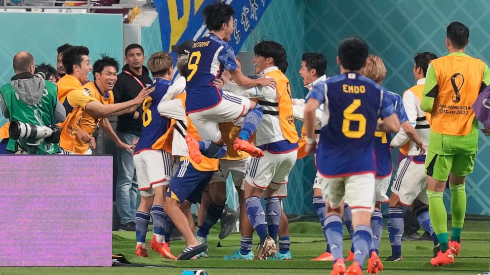 Japan players celebrate after Takuma Asano scored his side's second goal during the World Cup group E soccer match between Germany and Japan, at the Khalifa International Stadium in Doha, Qatar, Wednesday, Nov. 23, 2022. (AP Photo/Eugene Hoshiko)