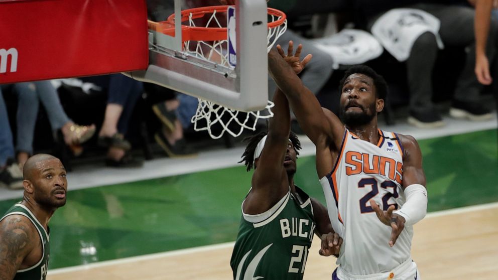 Phoenix Suns' Deandre Ayton (22) shoots against Milwaukee Bucks' Jrue Holiday (21) during the first half of Game 3 of basketball's NBA Finals, Sunday, July 11, 2021, in Milwaukee. (AP Photo/Aaron Gash)
