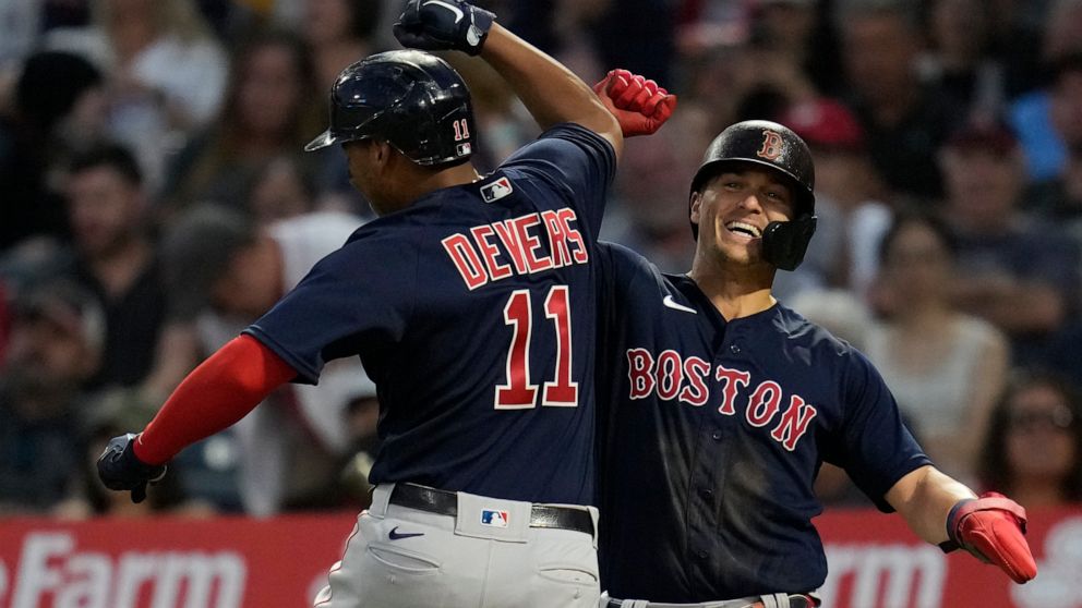 Boston Red Sox's Rafael Devers (11) celebrates with Enrique Hernandez, right after hitting a home run during the fourth inning of a baseball game against the Los Angeles Angels Monday, July 5, 2021, in Anaheim, Calif. (AP Photo/Ashley Landis)