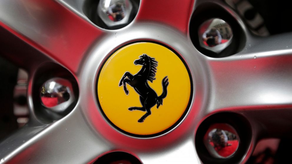 FILE - This Monday, Oct. 9, 2017 file photo shows a Ferrari logo on a car outside the New York Stock Exchange in New York. Luxury sportscar maker Ferrari says its chief executive, Louis Camilleri, has resigned for personal reasons. Chairman John Elka