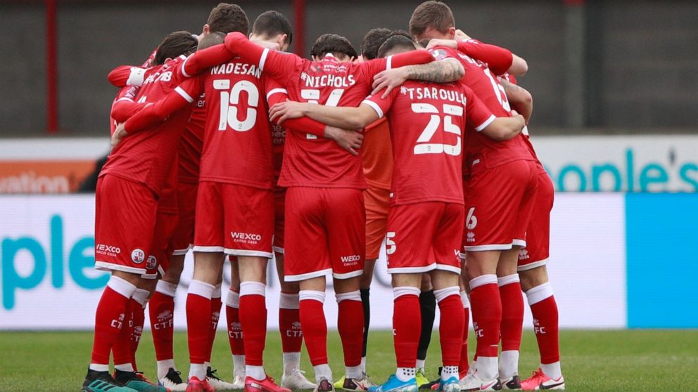 FILE - Crawley Town's players hug each other before the English FA Cup third round soccer match between Crawley Town and Leeds United at Broadfield Stadium in Crawley, England, on Jan. 10, 2021. An American consortium has bought Crawley Town with the