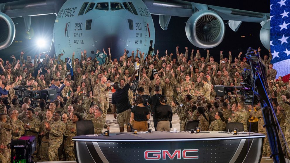 In this handout photo from the U.S. Air Force, American service members participate in a live broadcast with the hosts of Fox NFL Sunday during their Salute to Veterans broadcast, Nov. 13, 2022 at Al-Udeid Air Base in Qatar. As over a million World C