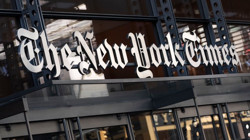 FILE - A sign for The New York Times hangs above the entrance to its building on May 6, 2021 in New York. The New York Times Co. is buying sports site The Athletic for $550 million, drilling down on subscriptions as the newspaper print ads business f
