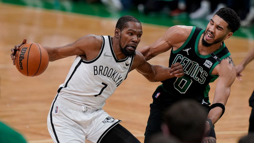 Brooklyn Nets forward Kevin Durant (7) looks for an opening around Boston Celtics forward Jayson Tatum (0) in the second half of Game 1 of an NBA basketball first-round Eastern Conference playoff series, Sunday, April 17, 2022, in Boston. The Celtics