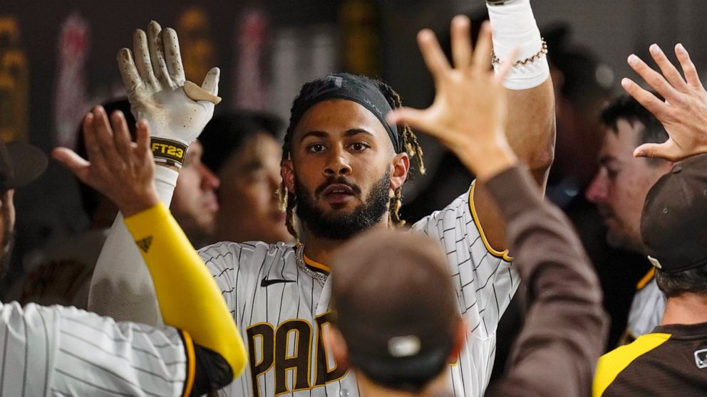 FILE - San Diego Padres' Fernando Tatis Jr. reacts with teammates after hitting a home run during the seventh inning of a baseball game against the Atlanta Braves, Sept. 24, 2021, in San Diego. Tatis Jr.'s surgically repaired left wrist hasn't progre