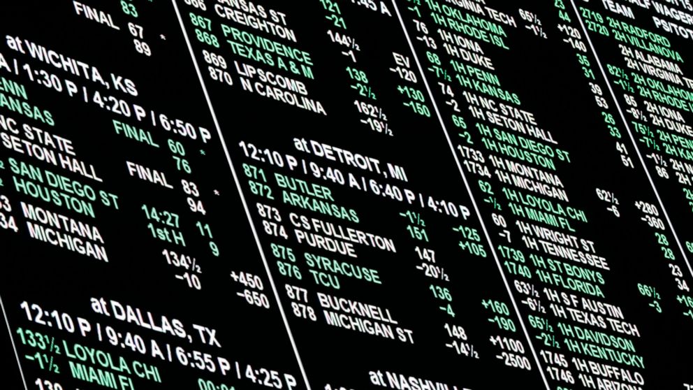 FILE - In this March 15, 2018, file photo, a board displays odds for different bets on the NCAA college basketball tournament at the Westgate Superbook sports book in Las Vegas. The sports books are closed, and the only things left to bet on mobile a