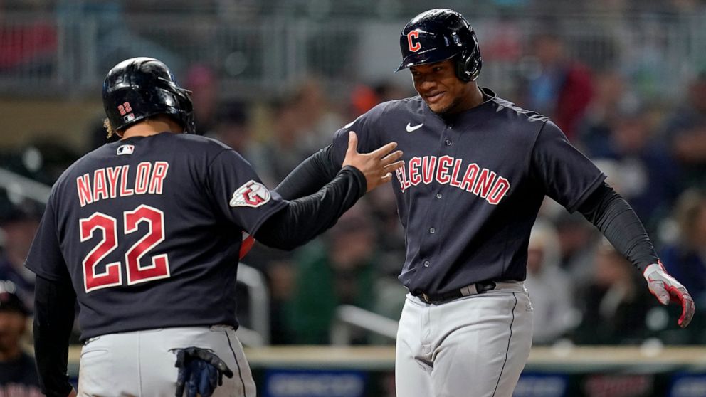 Cleveland Guardians' Oscar Gonzalez, right, celebrates with Cleveland Guardians' Josh Naylor, left, after hitting a two-run home run during the fifth inning of a baseball game against the Minnesota Twins, Friday, Sept. 9, 2022, in Minneapolis. (AP Ph