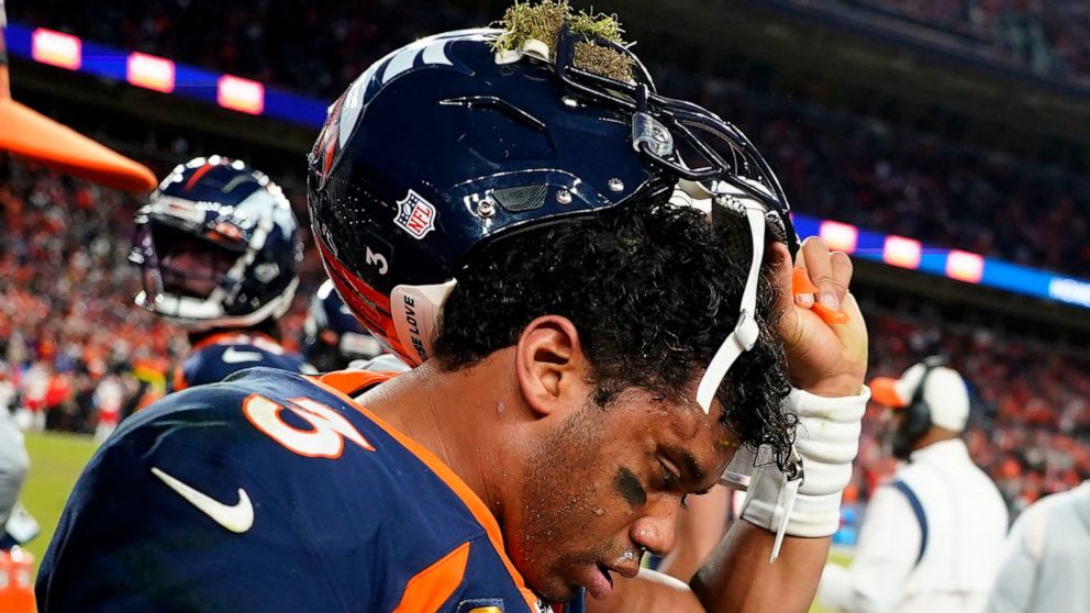 Denver Broncos quarterback Russell Wilson (3) removes his helmet after a concussion against the Kansas City Chiefs during the second half of an NFL football game, Sunday, Dec. 11, 2022, in Denver. (AP Photo/Jack Dempsey)