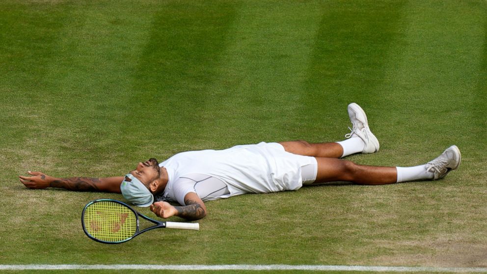 Australia's Nick Kyrgios lies on the ground after defeating Chile's Cristian Garin during a men's singles quarterfinal match on day ten of the Wimbledon tennis championships in London, Wednesday, July 6, 2022. (AP Photo/Alastair Grant)