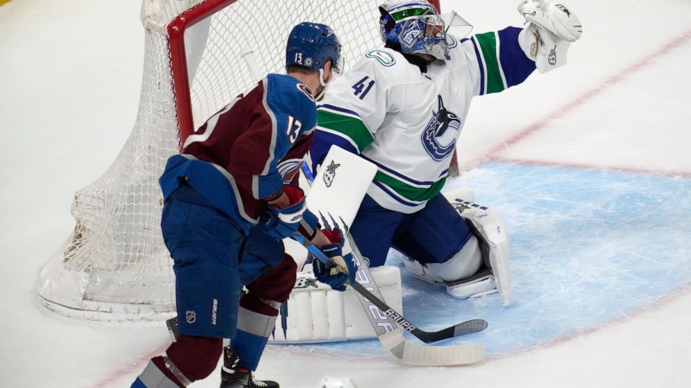 Vancouver Canucks goaltender Jaroslav Halak, right, makes a glove save as Colorado Avalanche right wing Valeri Nichushkin watches during the first period of an NHL hockey game Wednesday, March 23, 2022, in Denver. (AP Photo/David Zalubowski)