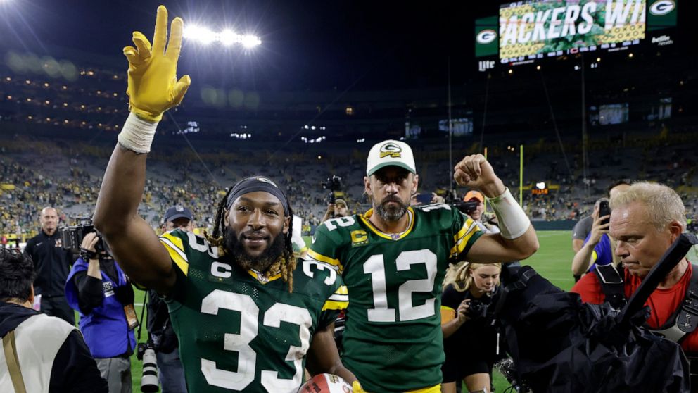 Green Bay Packers running back Aaron Jones (33) and quarterback Aaron Rodgers (12) walk off the field after an NFL football game against the Chicago Bears Sunday, Sept. 18, 2022, in Green Bay, Wis. The Packers won 27-10. (AP Photo/Mike Roemer)