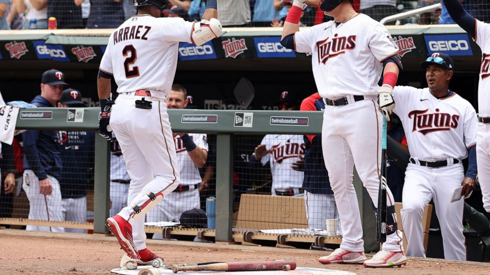 Minnesota Twins' Luis Arraez (2) high-fives Jose Miranda after hitting a grand slam during the third inning of a baseball game against the Tampa Bay Rays, Saturday, June 11, 2022, in Minneapolis. (AP Photo/Stacy Bengs)