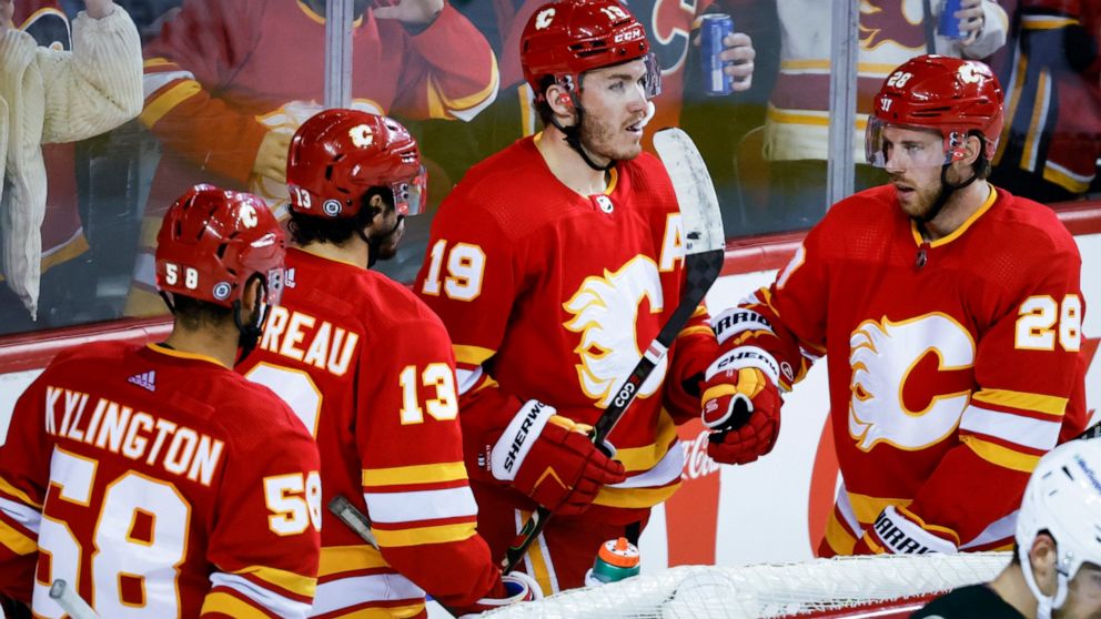 Calgary Flames' Matthew Tkachuk, second from right, celebrates his goal against the Arizona Coyotes with teammates during the third period of an NHL hockey game Saturday, April 16, 2022, in Calgary, Alberta. (Jeff McIntosh/The Canadian Press via AP)