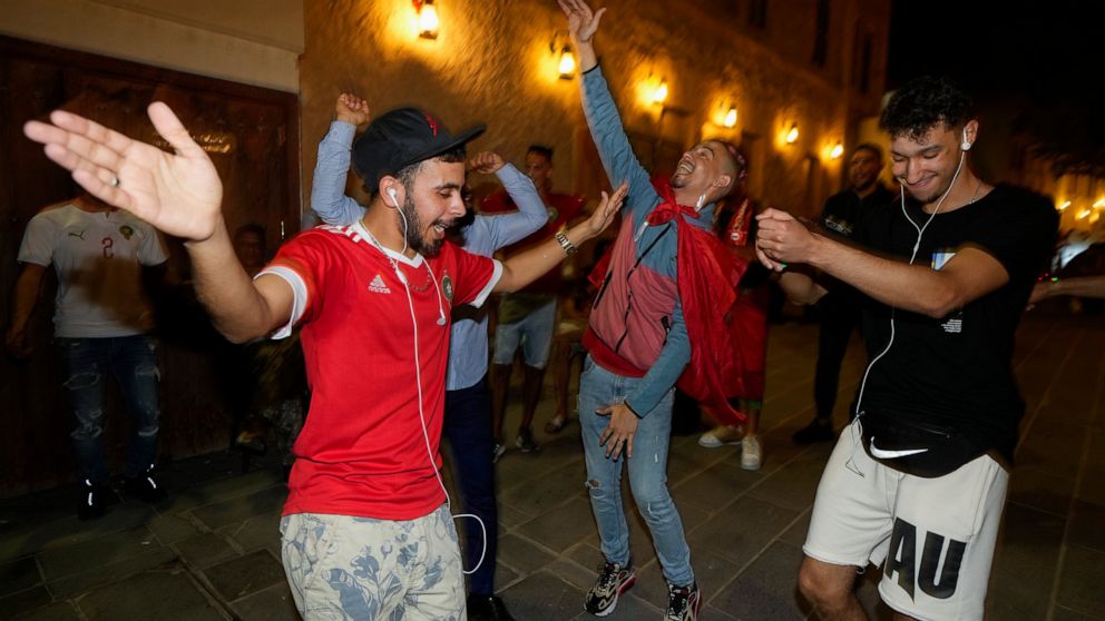 Moroccan soccer fans dance at the Souq Waqif during the FIFA World Cup, in Doha, Qatar on Sunday Dec. 4, 2022. (AP Photo/Ashley Landis)