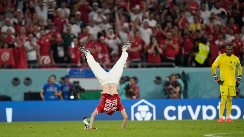 A Tunisian soccer fan invades the pitch during the World Cup group D soccer match between Tunisia and France at the Education City Stadium in Al Rayyan , Qatar, Wednesday, Nov. 30, 2022. (AP Photo/Christophe Ena)