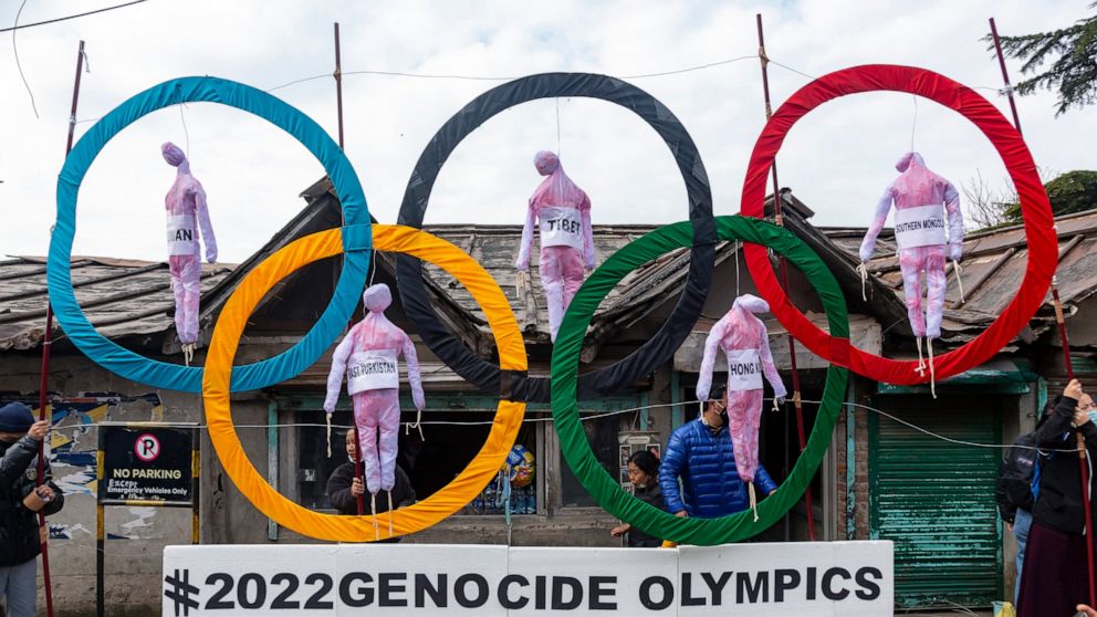 FILE - In this Feb. 3, 2021, file photo, exile Tibetans use the Olympic rings as a prop as they hold a protest against the holding of the 2022 Beijing Winter Olympics, in Dharmsala, India. Facing the boycott-threatened Beijing Winter Olympics in just