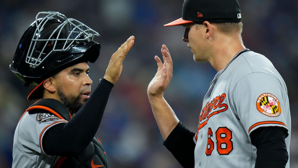 Baltimore Orioles pitcher Tyler Wells (68) high-fives catcher Robinson Chirinos (23) during sixth inning of a baseball game against the Toronto Blue Jays in Toronto on Thursday, June 16, 2022. (Nathan Denette/The Canadian Press via AP)