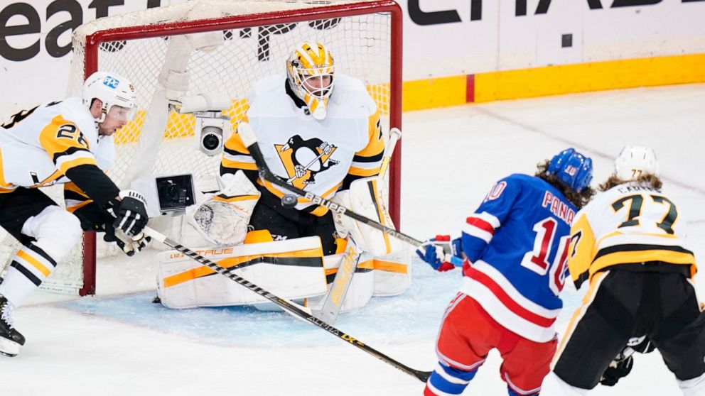 Pittsburgh Penguins goaltender Louis Domingue (70) stops a shot on goal by New York Rangers' Artemi Panarin (10) during the second period of Game 5 of an NHL hockey Stanley Cup first-round playoff series Wednesday, May 11, 2022, in New York. (AP Phot