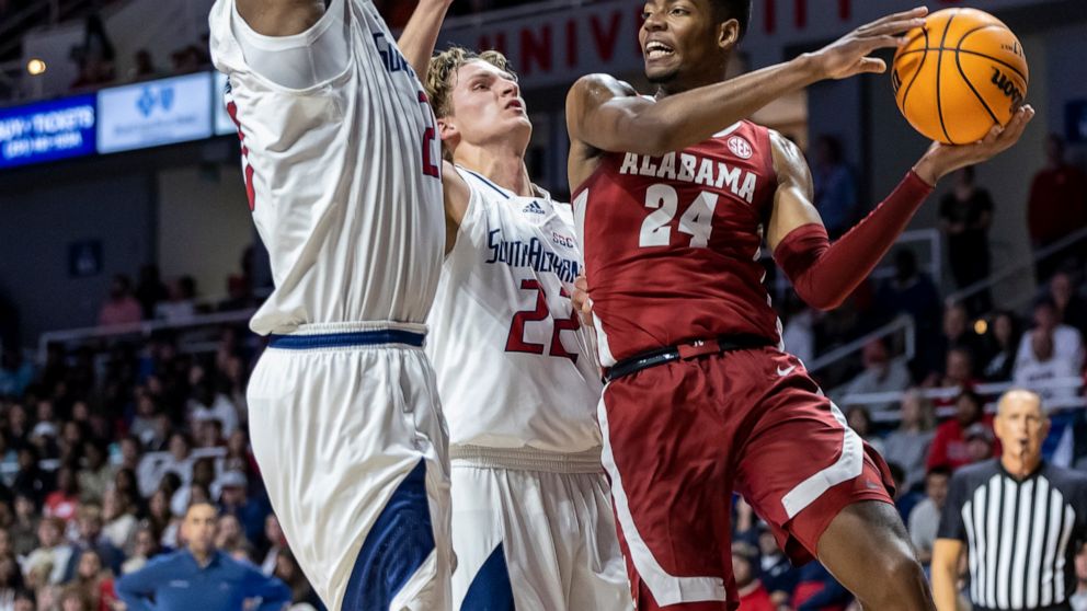 Alabama forward Brandon Miller (24) works against South Alabama center Kevin Samuel (21) and guard Owen White (22) during the first half of an NCAA college basketball game Tuesday, Nov. 15, 2022, in Mobile, Ala. (AP Photo/Vasha Hunt)