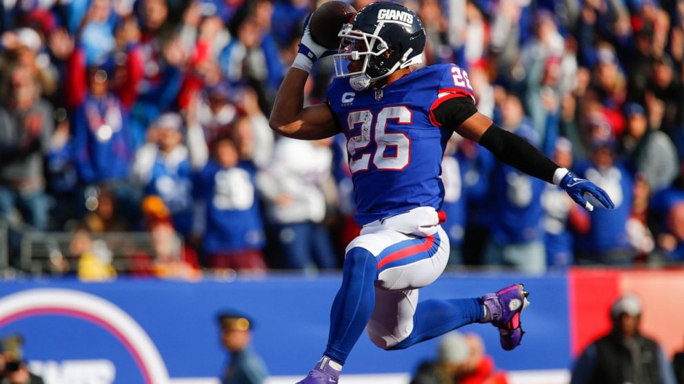 New York Giants' Saquon Barkley leaps into the end zone during the first half of an NFL football game against the Washington Commanders, Sunday, Dec. 4, 2022, in East Rutherford, N.J. (AP Photo/John Munson)
